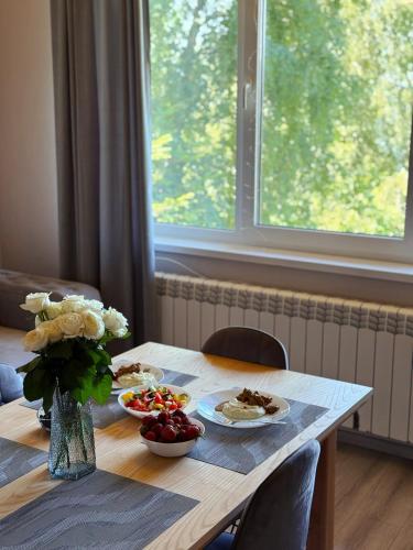 a table with two plates of food and flowers on it at Vista Krasiya in Vyshka