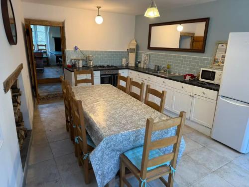 a kitchen with a dining table and a refrigerator at L'Ancienne Saboterie in Plorec-sur-Arguenon