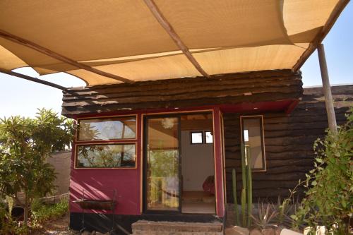 a house with a red door under an umbrella at Santuario Cosmico Mamalluca in Vicuña