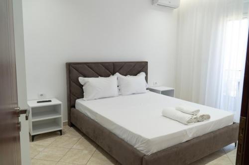 a bedroom with a large bed with white sheets at Villa Merkaj in Sarandë