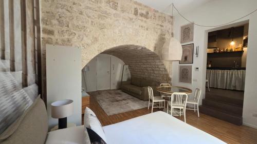 a bedroom with a bed and a table in a room at La Caverna - Bari Vecchia, Fronte Mare in Bari