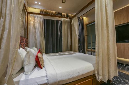 a bedroom with a large bed with white sheets and pillows at Aceotel Select Aria, Bhopal -A Luxury Boutique Hotel in Bhopal