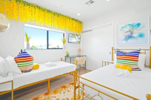 a room with two beds and a table at H- Fab Family 5BD 4,5BA NoHo Escape Near Universal with Games, Deck, Parking in North Hollywood