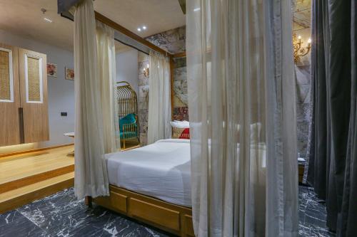 a bedroom with a bed with curtains around it at Aceotel Select Aria, Bhopal -A Luxury Boutique Hotel in Bhopal