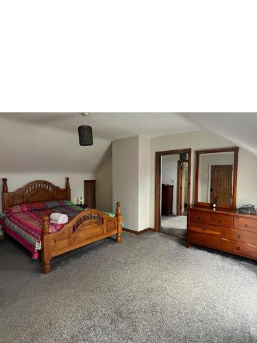 a bedroom with a bed and a dresser at The Portsalon House in Cloghfin