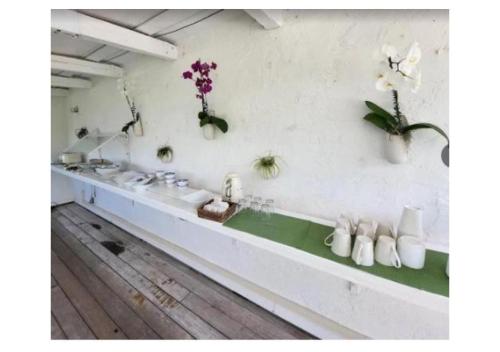 Un baño con lavabos blancos y plantas en la pared. en Casa Morada, en Islamorada