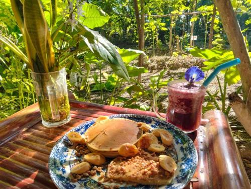 a table with a plate of food and a drink at daTerra Baucau agroecological farm stay in Deli