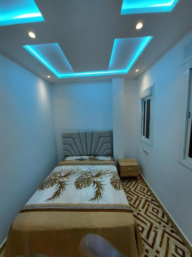 a bedroom with a bed with blue lights on the ceiling at Arizona Hotel in Martil