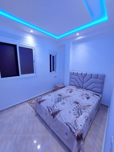 a bedroom with a bed in a room with blue lights at Arizona Hotel in Martil