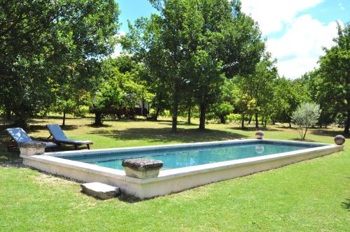 una piscina en el césped en un patio en La roulotte Chic et Boheme, en Mazan