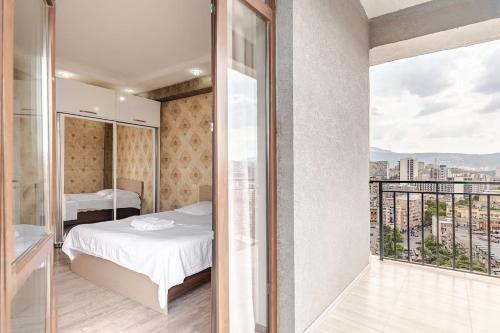a bedroom with a bed and a balcony with a view at SkyView Luxe City View Apartment Saakadze Square in Tbilisi City
