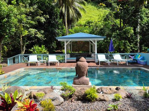 a small swimming pool with a gazebo in a garden at Ecolodge Mata Api Fare Tiare in Mataiea