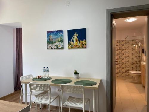 eine Küche mit einem Tisch und Stühlen sowie ein Badezimmer in der Unterkunft Apartament Corvin 3 in Hunedoara