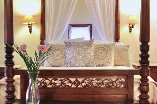 una cama con un jarrón de flores sobre una mesa en La Petite Maison- Fairytale Stay in Village Center, en Beynac-et-Cazenac