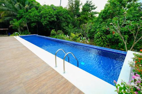 a swimming pool with two metal rails next to some trees at The Weekend Farmer in Alfonso