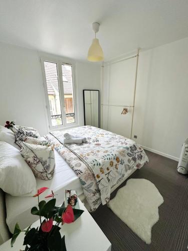 a bedroom with a bed with a comforter and a table at L'écrin d'Orphée in Bagnolet