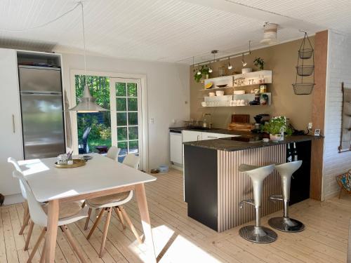 Una cocina con una mesa y sillas en una habitación. en The forest cottage with petanque court, en Nykøbing Sjælland