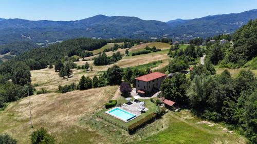 una vista aérea de una casa en una colina con piscina en Casale Sambuceto, en Compiano