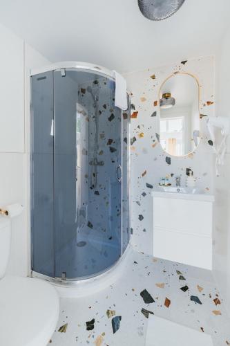 a bathroom with a glass shower with a mirror at My Slow Stay Łeba in Szczenurze