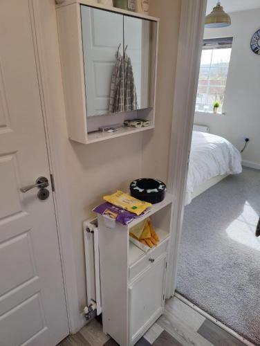 a bedroom with a white cabinet and a bed at Sgt Mark Stansfield Way in Mottram