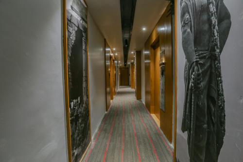 a hallway with a long corridor with paintings on the walls at Aceotel Select Aria, Bhopal -A Luxury Boutique Hotel in Bhopal