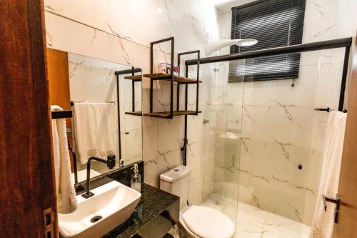 a bathroom with a toilet and a sink at Apartamento Villa Siena Condomínio À Beira Mar próximo ao Aeroporto in Salvador