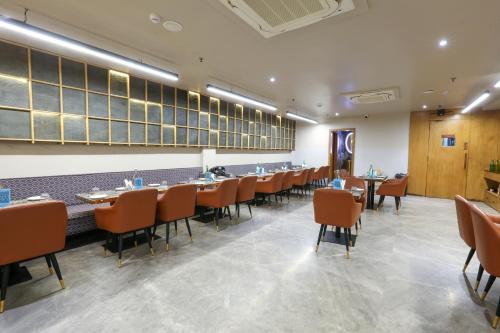 a dining room with tables and chairs at Aceotel Select Aria, Bhopal -A Luxury Boutique Hotel in Bhopal