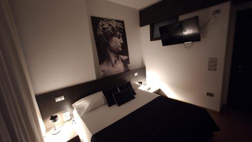 a bedroom with a black and white bed and a television at Attico Reale - in Centro, tra Stazione e Bari Vecchia in Bari