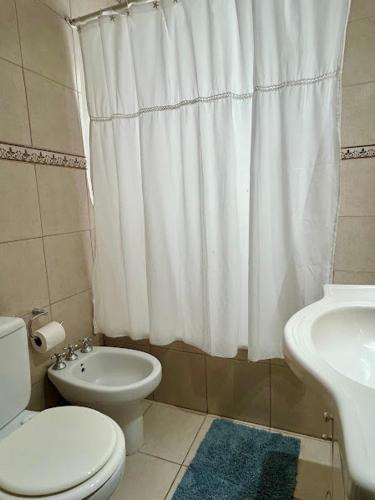 a bathroom with a toilet and a sink and a shower at Departamento amplio Olivos 