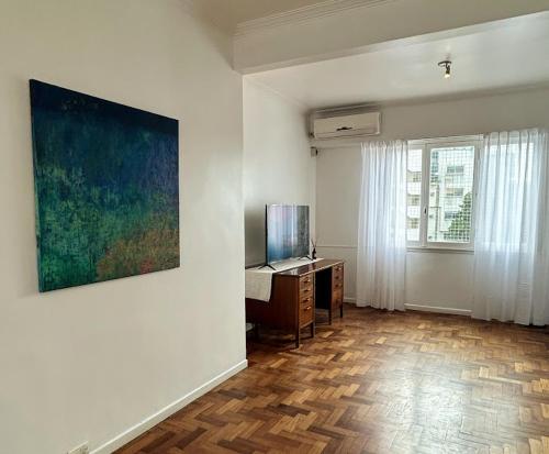 a room with a desk and a painting on the wall at Departamento amplio Olivos 