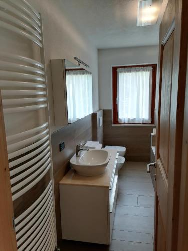 a bathroom with a sink and two toilets at Casa di Bambi in Valdidentro