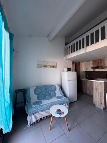 une petite pièce avec un lit et une table dans l'établissement Tout cosy à 200 m de la plage, à Argelès-sur-Mer