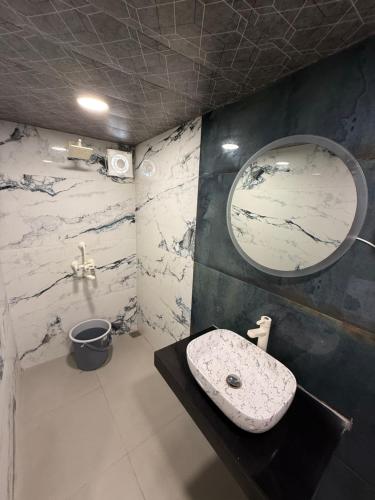 a bathroom with a sink and a mirror at Hotel Shahjahan in Agra