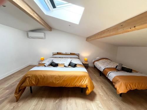 two beds in a attic bedroom with a skylight at MAISON T3 avec extérieur 5 couchages, 3 lits, 2 chambres, BORDEAUX à 10min, TRAM C à 200m, Parc jeux enfants in Le Bouscat