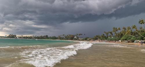 Una vista de una playa con gente en el agua. en Lahima Cabanas Villa, en Dikwella
