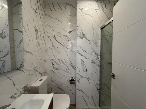 a white bathroom with a toilet and a sink at Gabika Apartment 4 in Bilbao