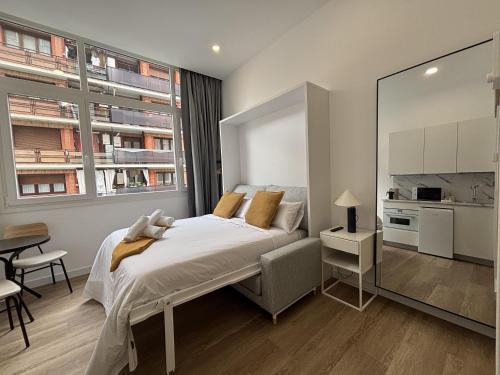 a bedroom with a large bed and a kitchen at Gabika Apartment 4 in Bilbao