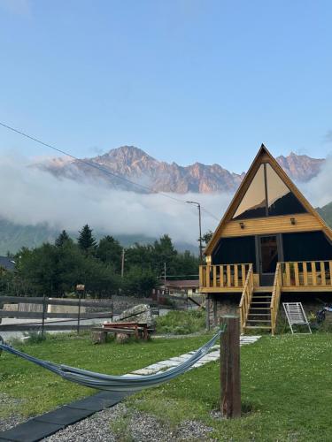 a log cabin with a hammock in front of it at Cottage Carpe Diem in Stepantsminda