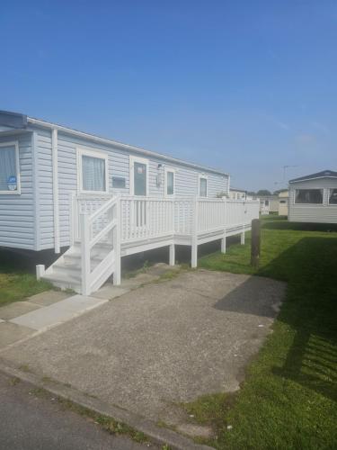 a mobile home with a porch and a deck at Caravan to Hire - CalaGran Fleetwood Blackpool in Fleetwood