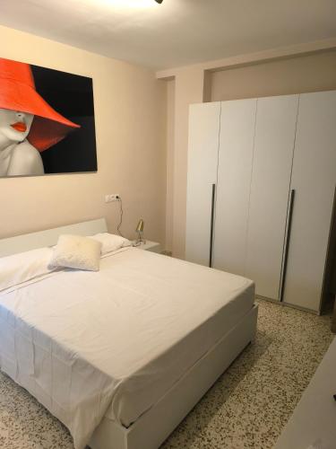 1 dormitorio con 1 cama con sombrero rojo en Casacasini 1A, en Málaga