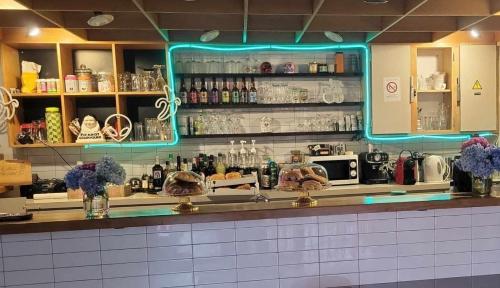 un bar con una luce blu sopra il bancone di Chalet privé résident - camping la raviège a La Salvetat