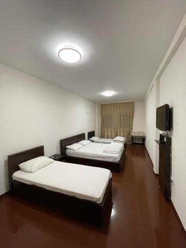 a room with three beds and a flat screen tv at Hotel Iliria in Orllan