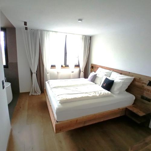 a bedroom with a large bed with white sheets and pillows at FeWo Passo-Palade in Tesimo