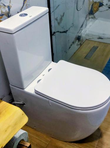 a white toilet in a room with a table at Sweet Home Aria in Çorovodë