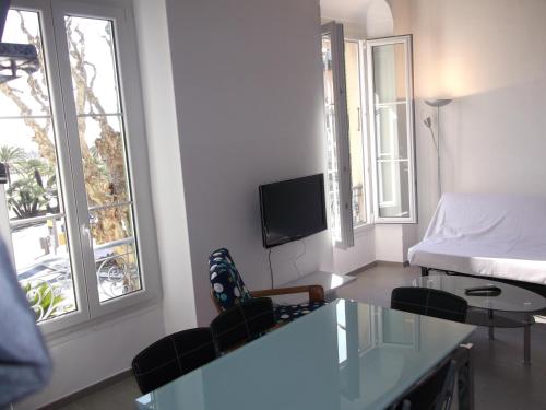 un salon avec un lit, une table et des chaises dans l'établissement Square Victoria, à Menton