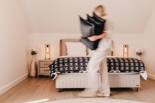 a woman is jumping in a room with a bed at Maison Idyllique in Bree