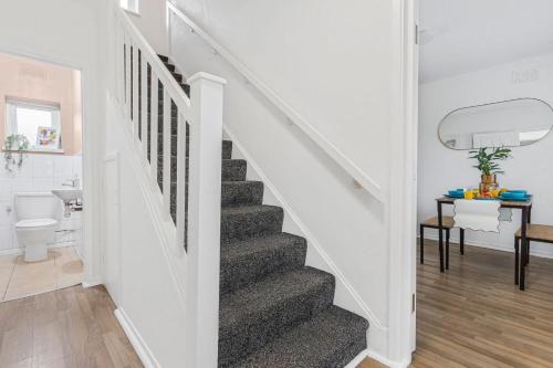 a white staircase in a home with a bathroom at Spacious 3BHK near Heathrow in Cranford
