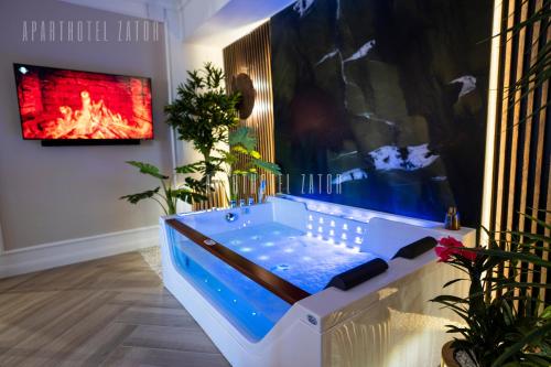 a jacuzzi tub in a room with a fireplace at Aparthotel ZATOR Retro 66 jacuzzi in Zator
