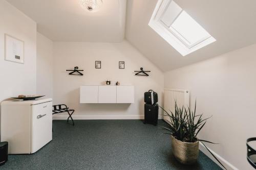 an attic room with a refrigerator and a window at Maison Idyllique in Bree