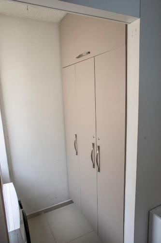 a white cabinet in a white room at B&B Apartamento acolhedor Bem localizado, Próximo ao aeroporto in São José dos Pinhais